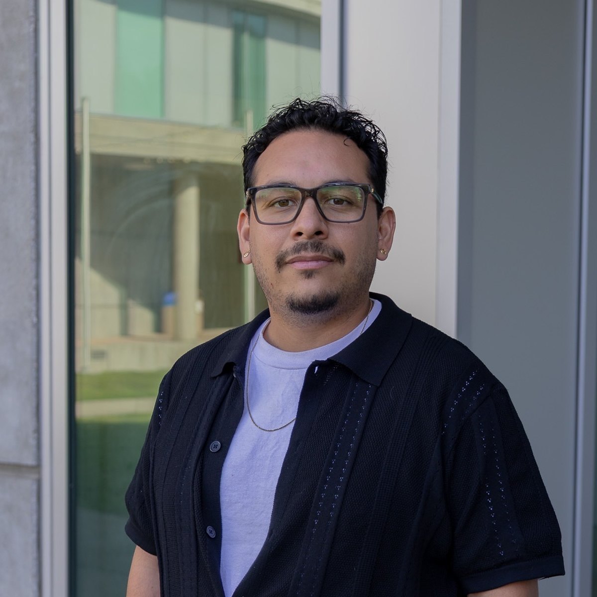 Josthin Amado, standing outdoors in front of a brick building